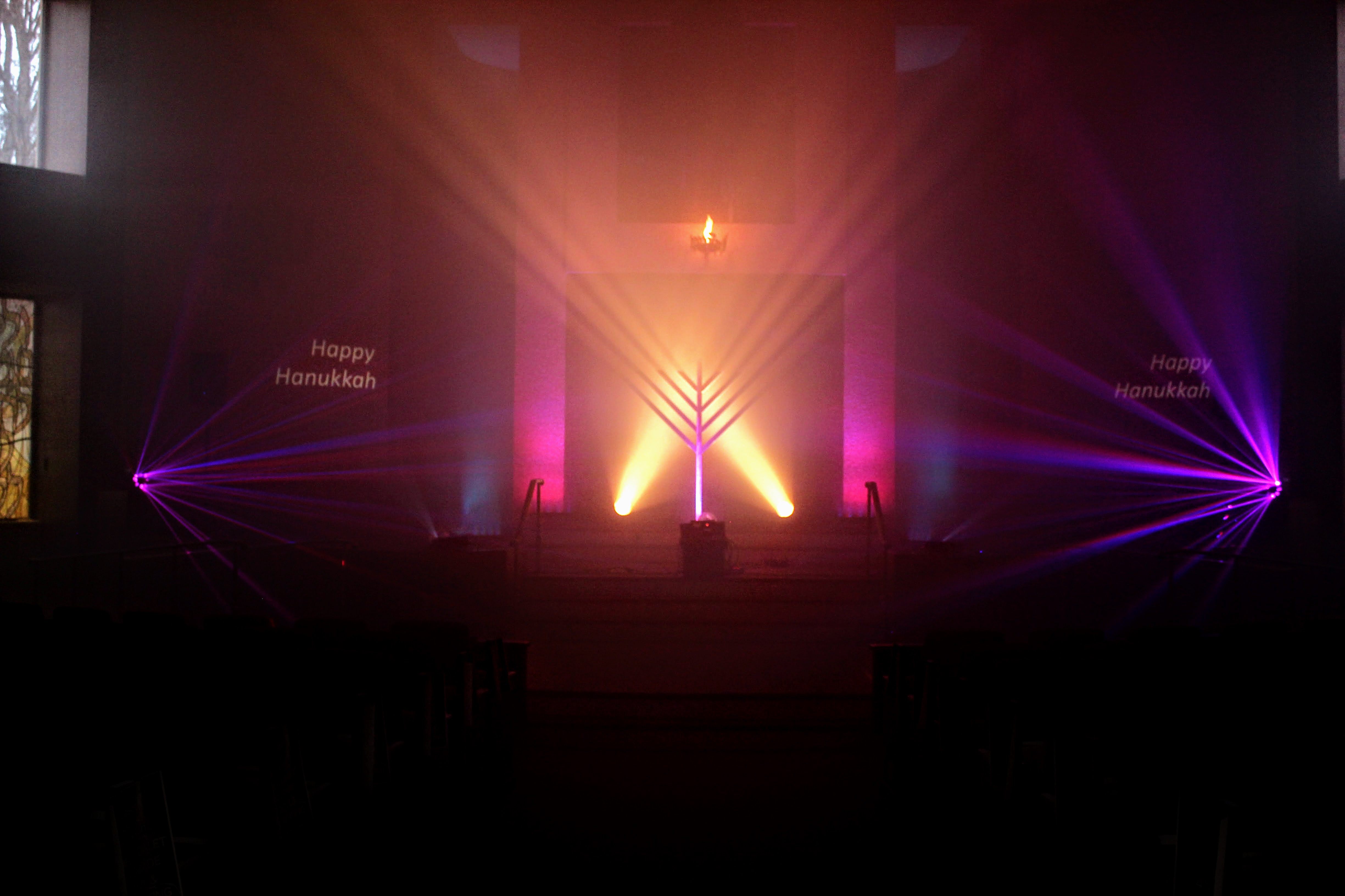 Warm stage with pink side beams during a Festival of Laser Light performance