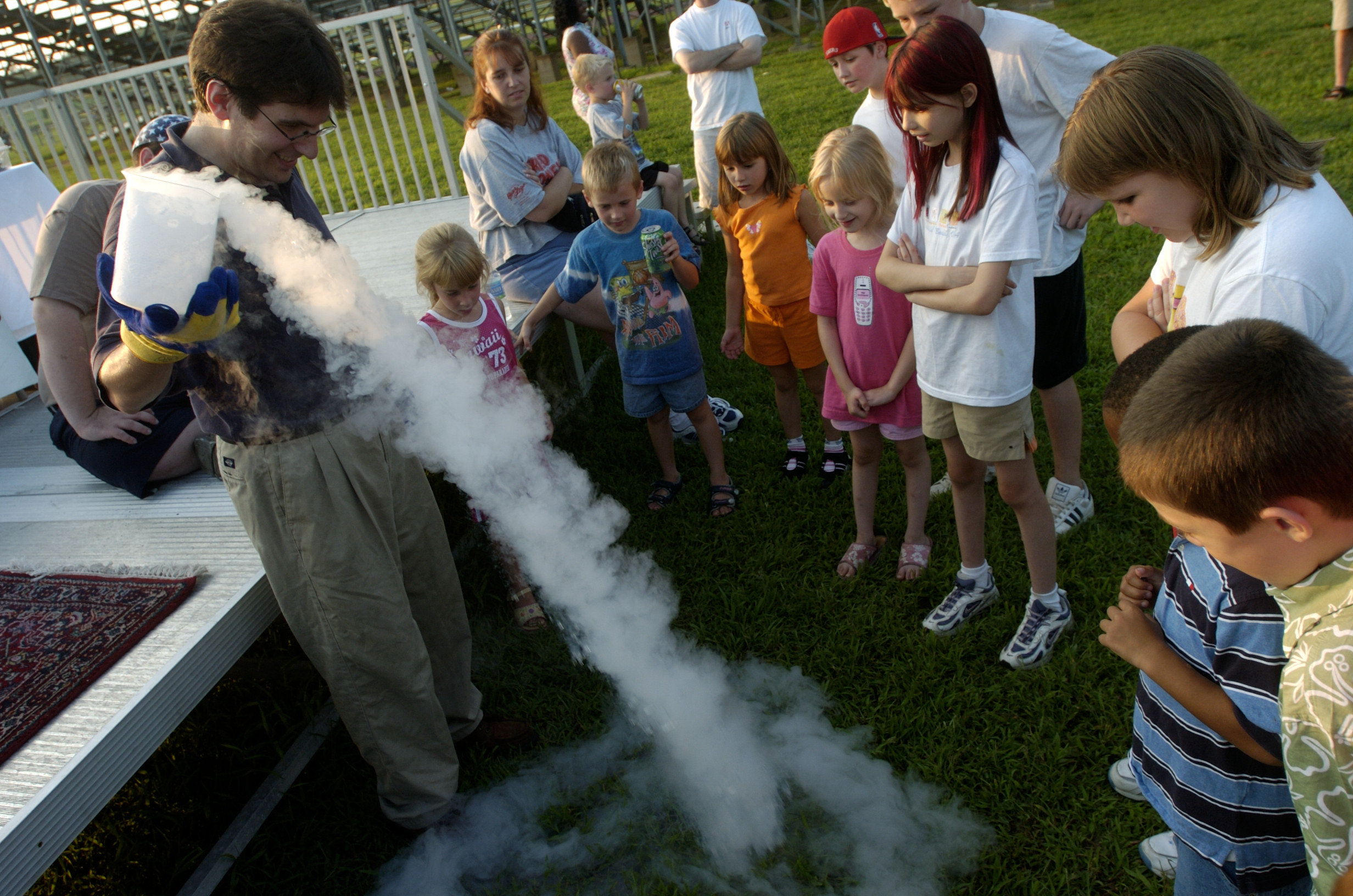 An outdoor nitrogen and smoke demonstration surrounded by delighted kids